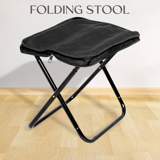 Folding Camping Stool set up in a lush green outdoor setting, ready for use.