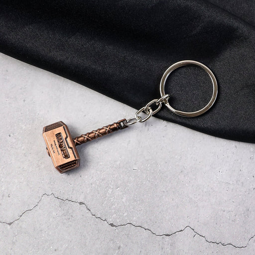Metal Hammer Keychain with antique bronze finish on neutral background