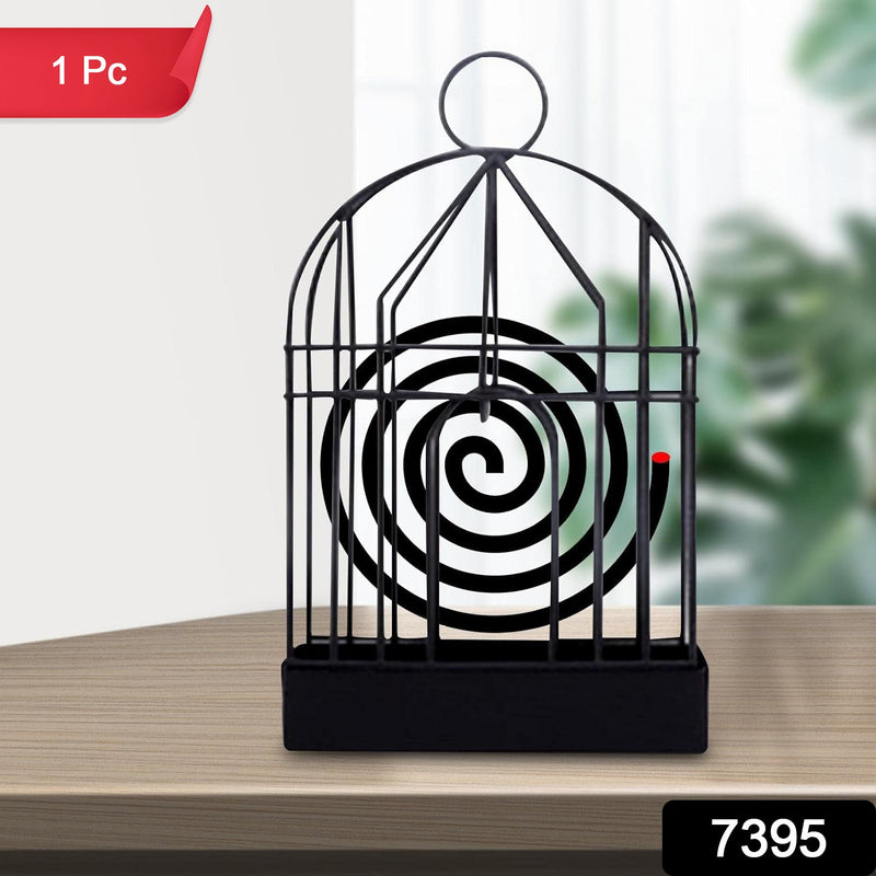 Iron birdcage mosquito coil holder placed on a rustic wooden table.