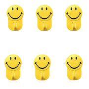 Close-up of a plastic smiley face hook demonstrating its self-adhesive backing.