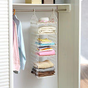 Various clothes, including pants and shirts, neatly hung on the different tiers of the folding clothes hanger.
