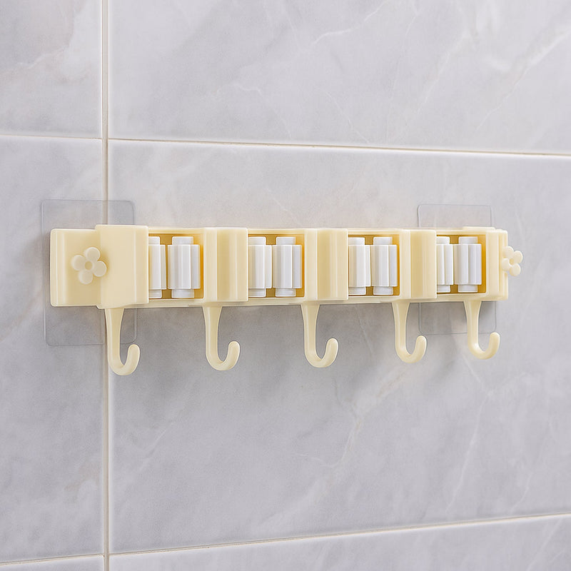 Self-adhesive broom and mop holder rack mounted on wall with utility hooks