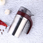 Sleek stainless steel oil dispenser with a small pouring nozzle on a white background.