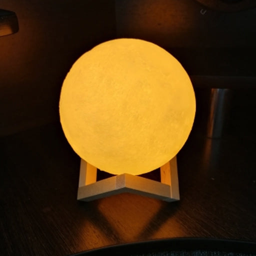 A beautifully lit 3D moon lamp with touch controls on an elegant crystal ball stand.