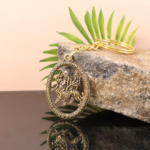 Front view of golden metal Durga Maa keychain featuring divine lion motif