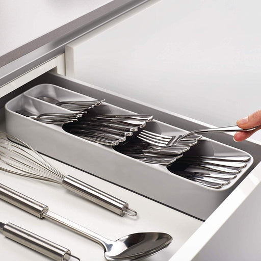 An empty, grey plastic cutlery tray with multiple compartments for kitchen drawer organisation.