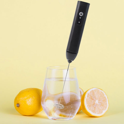 Electric handheld milk frother with stainless steel whisk in use