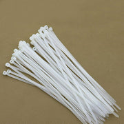 Flexible heavy-duty nylon cable ties being used to secure items outdoors.