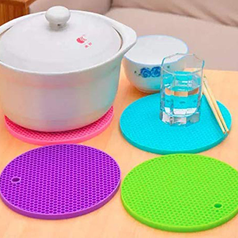 Close-up of a red silicone hot pot mat, highlighting its textured design for better grip.