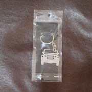 Jeep shaped metal keychain holding keys, displayed in hand