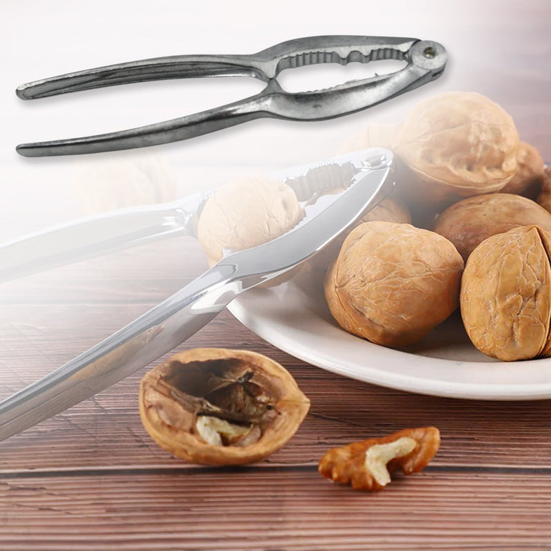Hand holding the compact stainless steel nut cracker, demonstrating its portability.