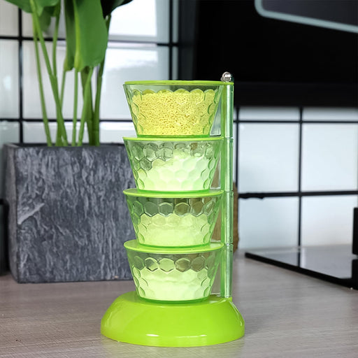  4-tier rotating spice rack with four transparent compartments and spoons.