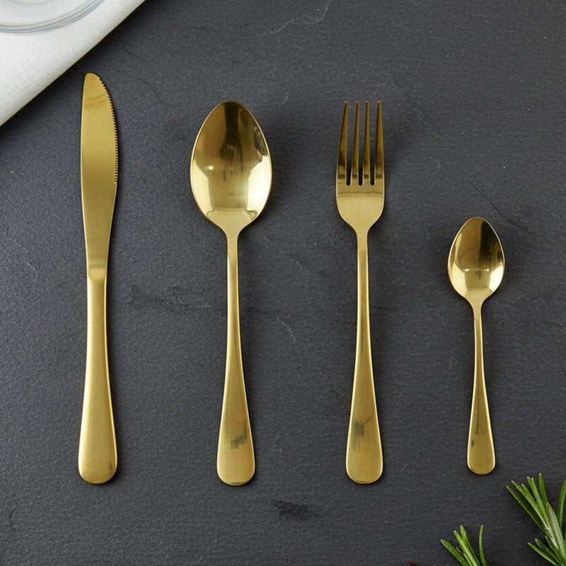 Gold spoons, forks, and knives laid out showcasing the set's completeness