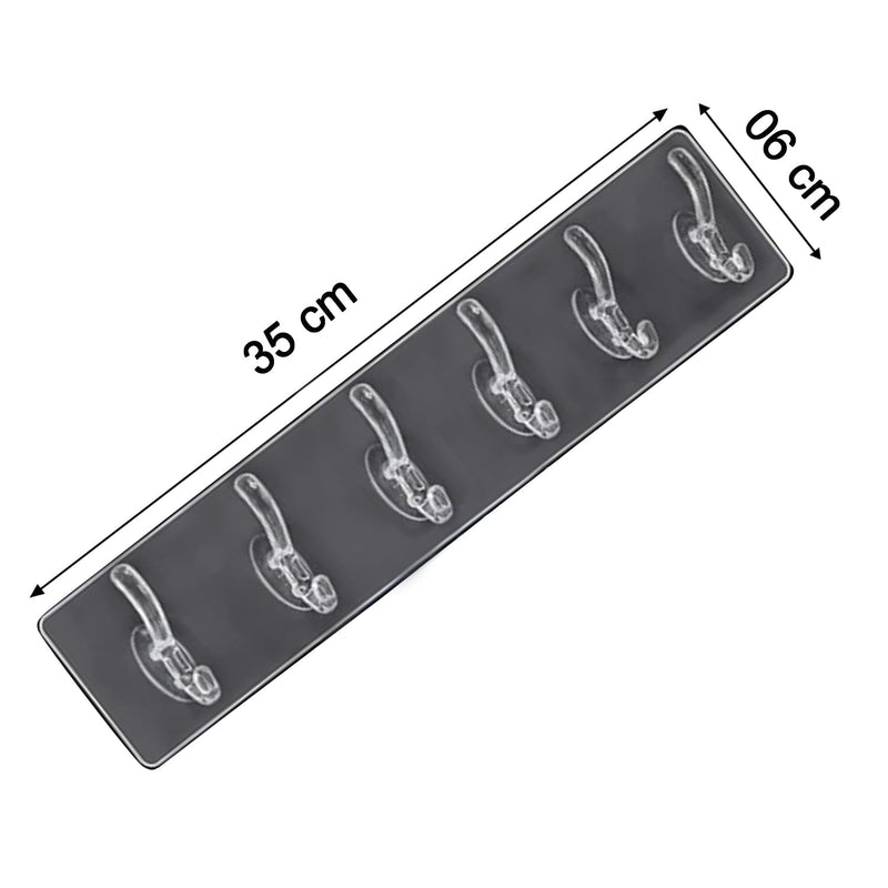 Elegant golden and transparent 6-pin hooks providing storage on a bathroom wall.