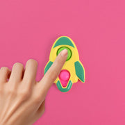 Child's hands playing with the rocket-shaped fidget keychain toy