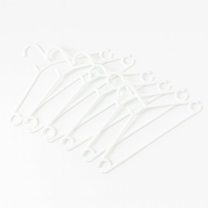 Stack of 6 white plastic clothes hangers ready for use