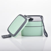Stackable green lunch box with multiple compartments for varied meals.