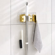 Space saving broom and mop hanger wall mounted with self adhesive base