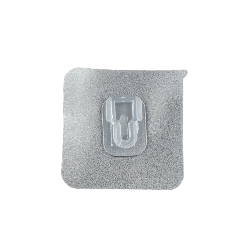 GlimmerHome transparent adhesive hook discreetly blending into a white wall.
