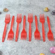 Stacked red disposable forks showing compact, portable design