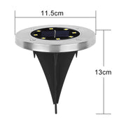 Single solar LED garden light glowing brightly at night in outdoor garden setting