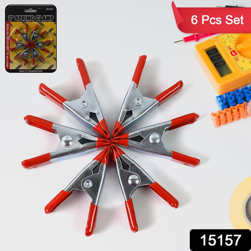 Set of 2-inch metal spring clamps securely holding various objects, demonstrating versatile grip.