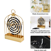 A lit mosquito coil safely burning inside the decorative birdcage holder.