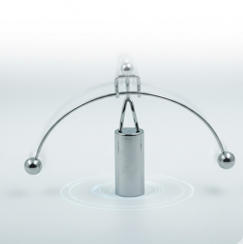 The Newton Cradle's metal balls in mid-swing, illustrating kinetic energy transfer.