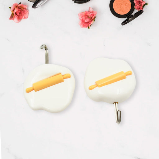 Multipurpose self-adhesive hooks organizing kitchen utensils and towels.