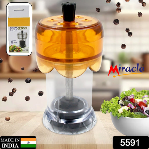 Hand demonstrating the manual operation of the transparent pepper mill.