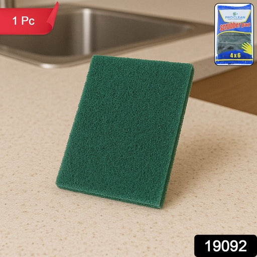 Green multipurpose kitchen scrubber pad removing grime on utensils