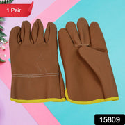 Close-up of leather gardening gloves protecting hands while pruning thorny rose bushes.