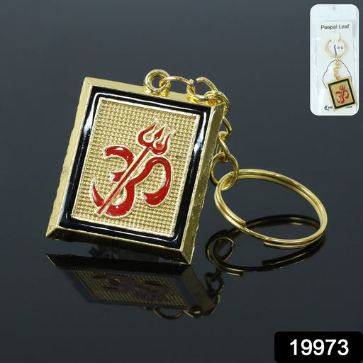 Close-up of metal keychain featuring Om Trishul symbol in golden finish