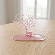 Base view of pink deer jewelry stand on table, India