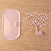 Pink deer jewelry stand with earrings displayed, India