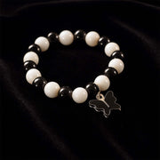 Close-up of black and white beads and cross pendant on bracelet