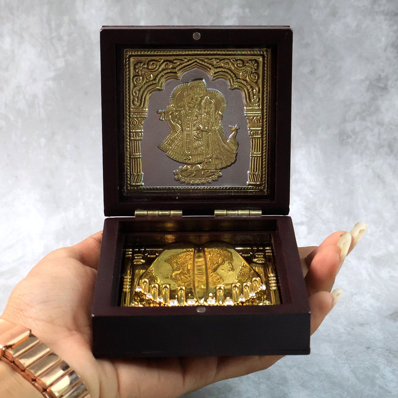 Video presenting golden Charan Paduka in wooden box used as devotional pooja accessory