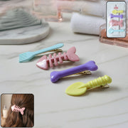 Set of four colourful cartoon hair clips for girls with animal and fruit designs.