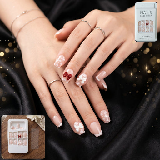Woman's hand with glitter 3D floral press-on nail tips showcasing detailed floral and crystal designs.