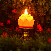 Close-up of lotus shaped LED candle with flickering effect on ornate holder