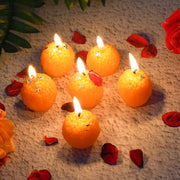 Orange laddu shaped wax candles with slow-burning wicks and silver leaf accents