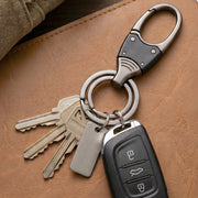 Hand holding compact metal key holder with rotating swivel