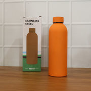Lifestyle image featuring stainless steel insulated orange water bottle