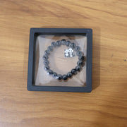 Lifestyle shot of black beaded stretch bracelet featuring cute panda charm on wrist.