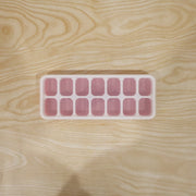 Pink ice cube tray in use for freezing