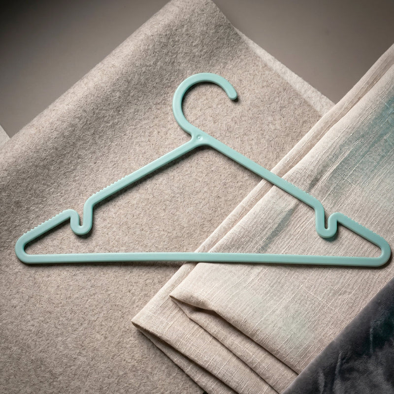 Plastic hanger holding shirt and dress, supporting heavy fabrics
