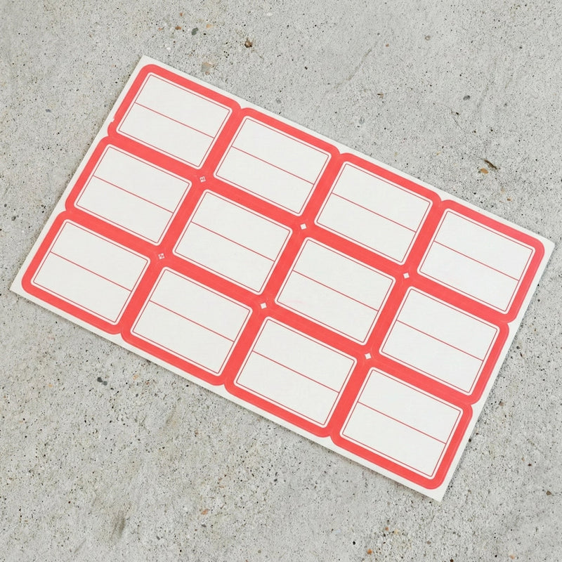 Close-up view of red and white rectangular self-adhesive label stickers