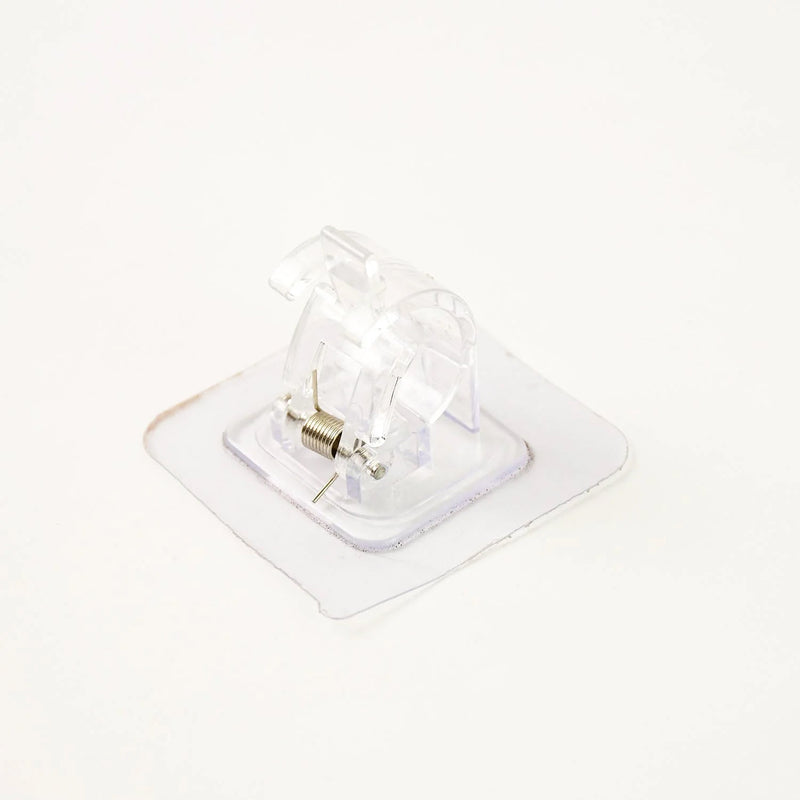 Self-adhesive curtain rail clip installed on wall for lightweight curtains