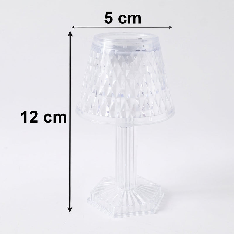 Small crystal table lamp creating a warm, ambient glow in a dark room.