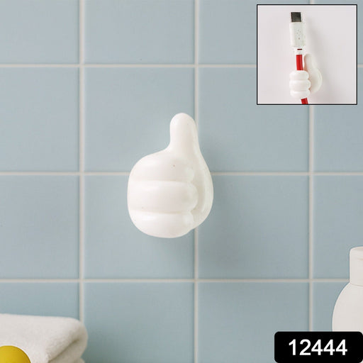 Close-up view of white palm-shaped multifunctional cable clip on wall
